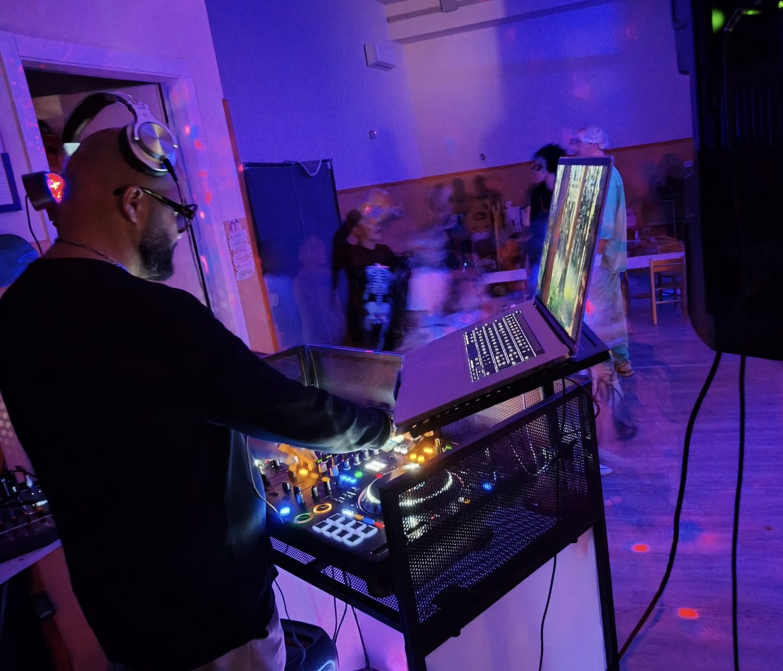 Fabrix DJ alla console con il portatile, luci viola