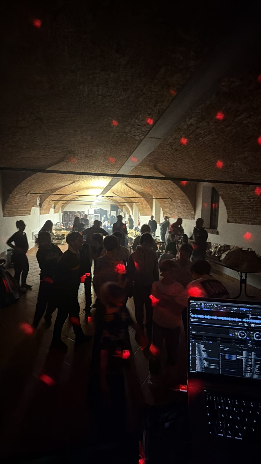 Festa in una sala con volta in mattoni e luci rosse